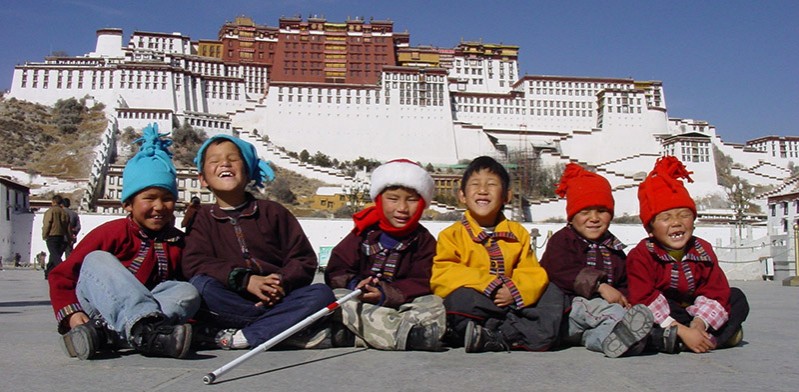 a group of tibetans sitting on the ground