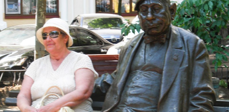 lady sitting next to a statue