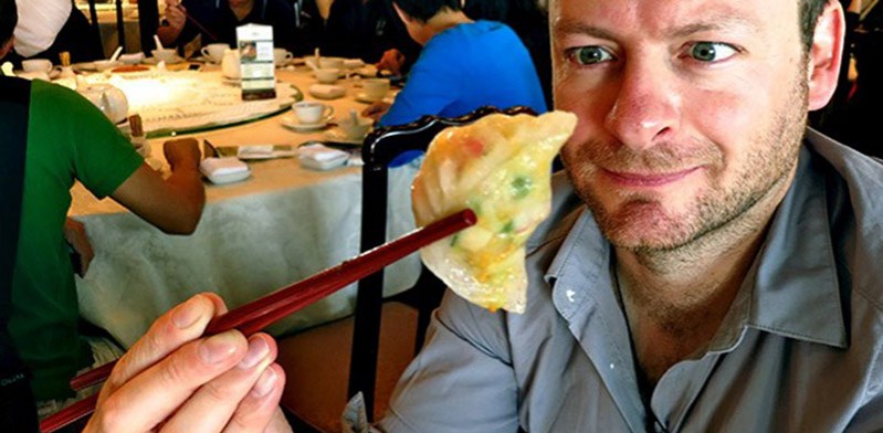 julian hanton with a gyoza in between chopsticks