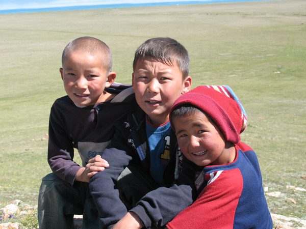Local Kyrgyz children join in a walk around the lake