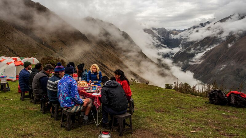 A group of hikers having lunch overlooking misty mountains on the Inca Trail trek, Peru
