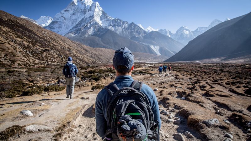 A man wearing a backpack looks at Mt Everest