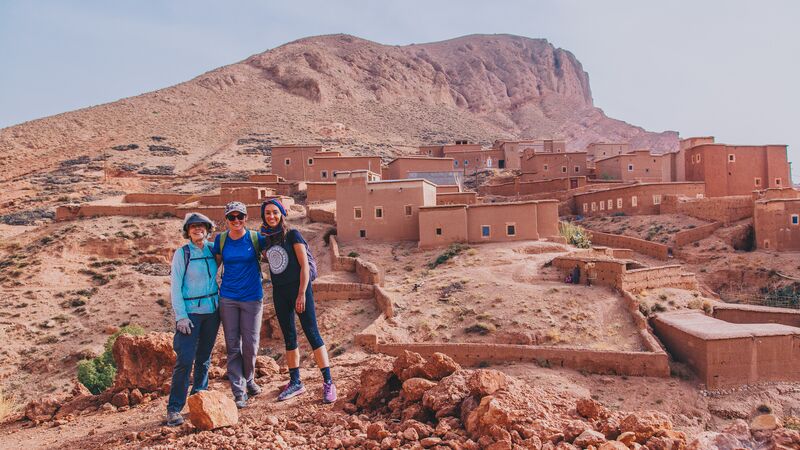 Three travellers standing in the desert in Morocco