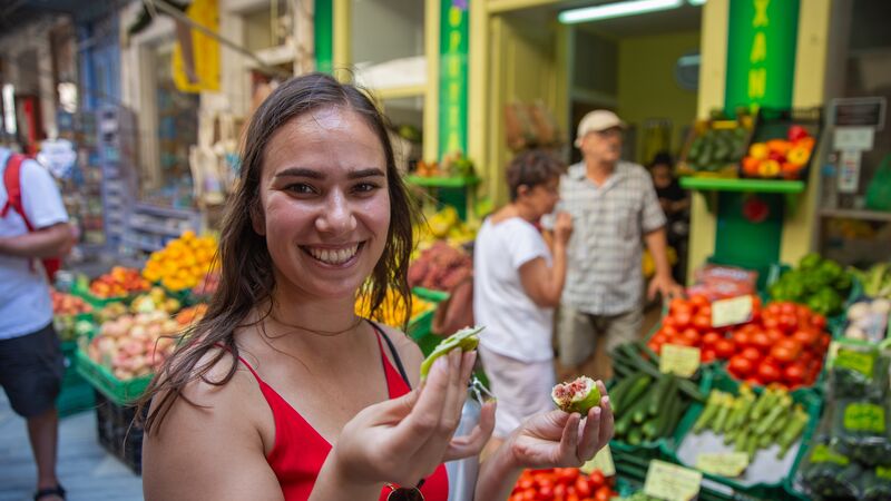 A girl eating a fig in a market