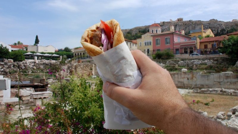 A man holds up a souvlaki in Greece