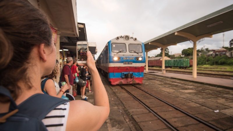 Girl takes photo of overnight train arriving at Hue station