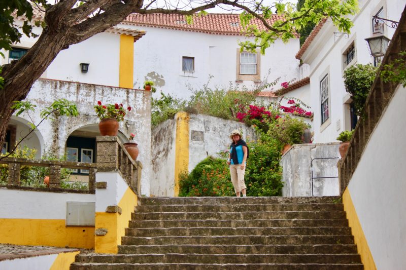 A traveller standing on steps in a street in Lisbon, Portugal