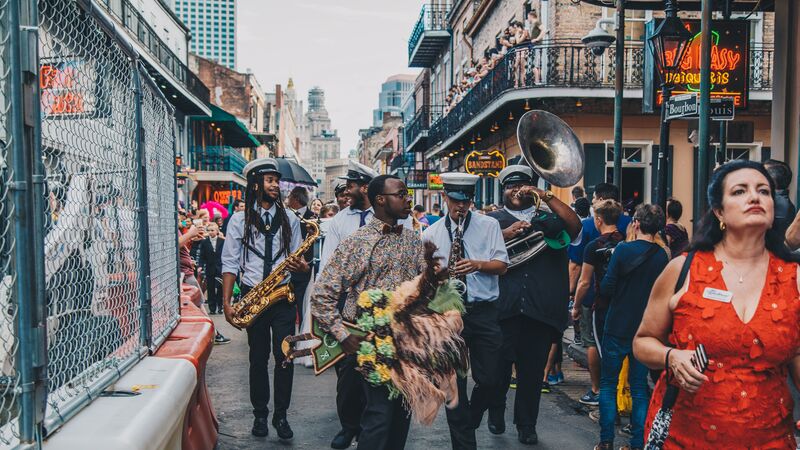 A marching band walking down a busy street in New Orleans