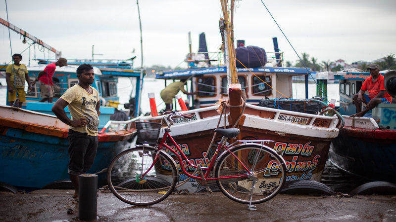 A local fisherman stands next to his bike. 