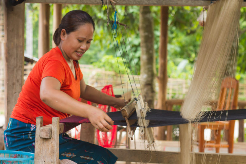 Laos Woman hand weaves textiles in Nong Khiaw