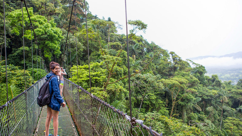 A traveller standing on an Arenal Hanging Bridge in Mistico Park, Costa Rica