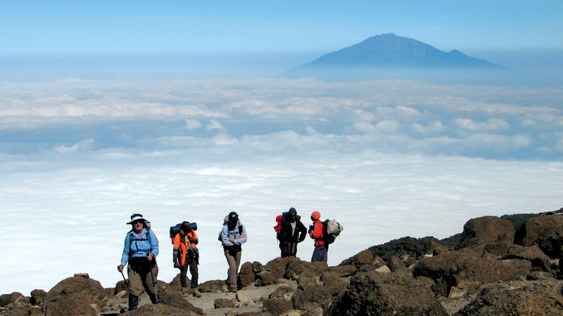 Climbers walking above the clouds on Kilimanjaro