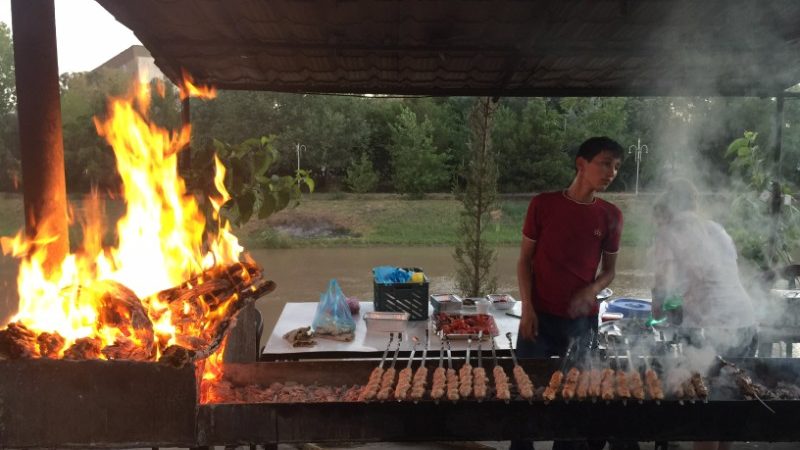 A man grills shashlyk over an open flame in Turkmenistan