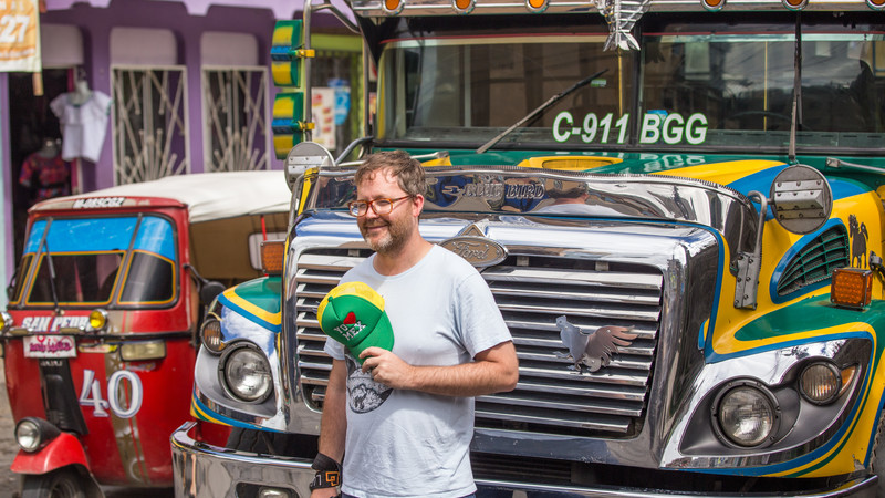 Traveler standing in front of a colorful bus