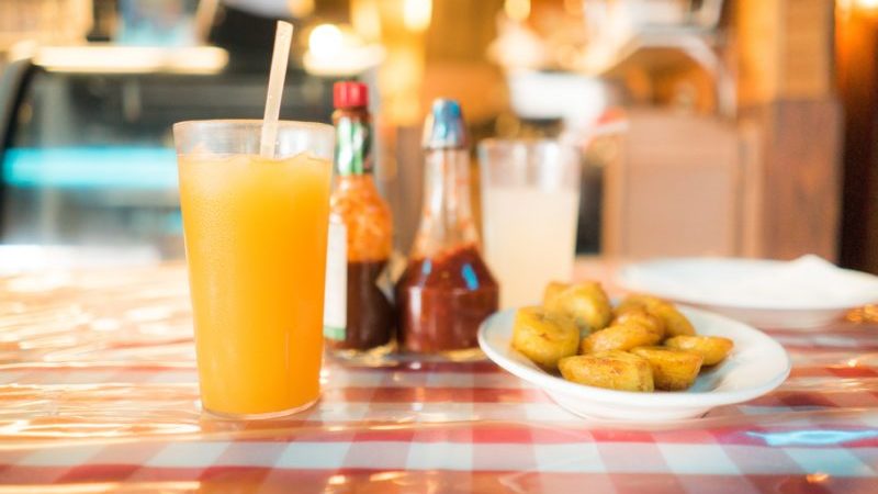 A glass of juice and bowl of potatoes at a US diner.