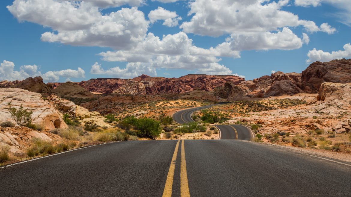 An open road stretches through the desert