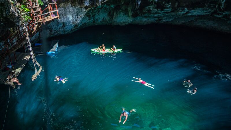 Swimmers and kayakers in a cenote in Mexico