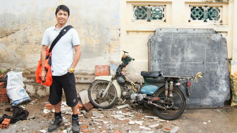 MAn standing in front of a motorbike in Vietnam