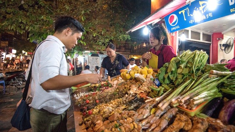 A man shops for dinner at a Hanoi night market