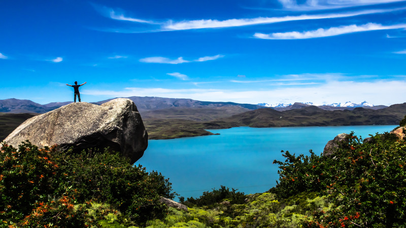 A traveller standing on a rocky outcrop in Torres del Paine National Park, Chile