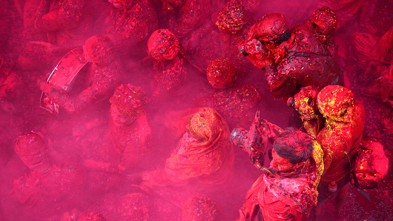 Festival goers covered in pink powder at Holi Festival in Uttar Pradesh, India