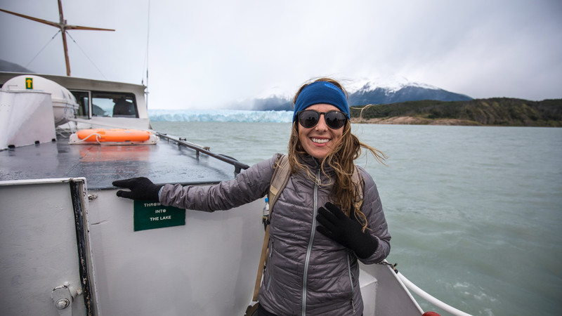 A smiling solo traveller on a boat in Patagonia