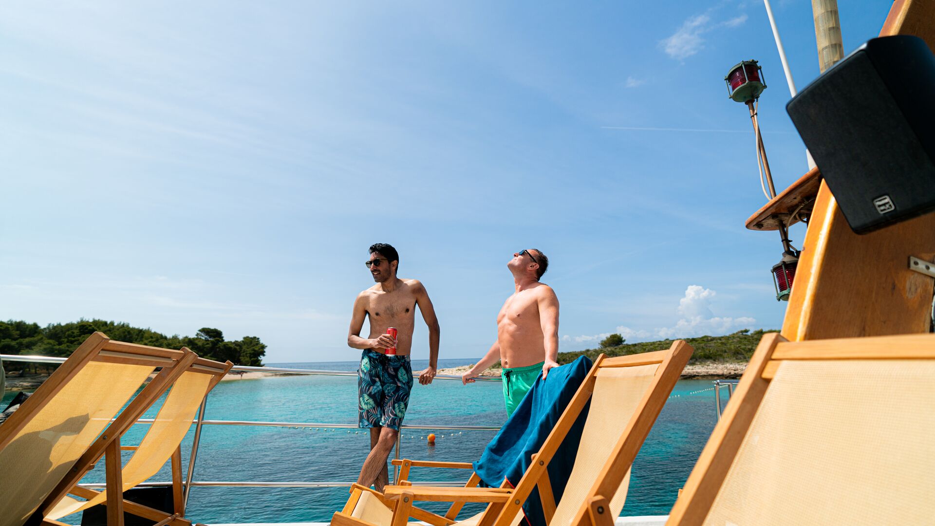 Two men stand on the deck of the boat in the sun, Croatia
