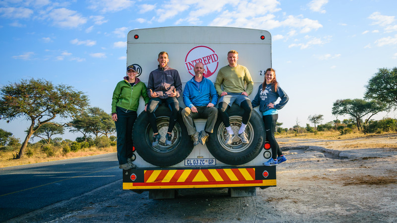 Passengers sitting on the back of a truck