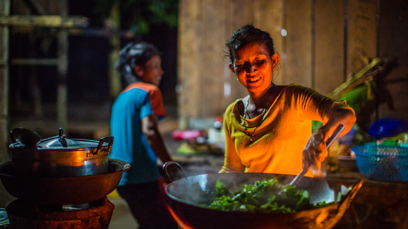 A woman cooks dinner at the homestay