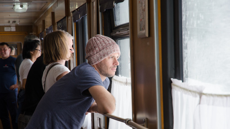 A passenger looks out the window on the train on the Trans Siberian Railway