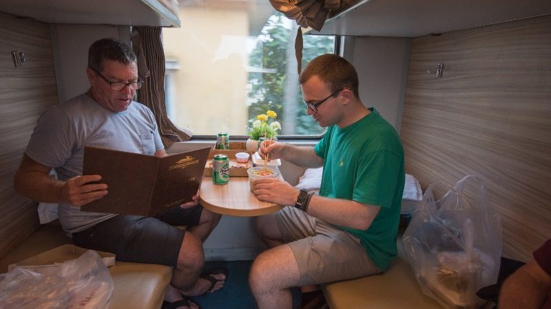 Two travellers have dinner on the train