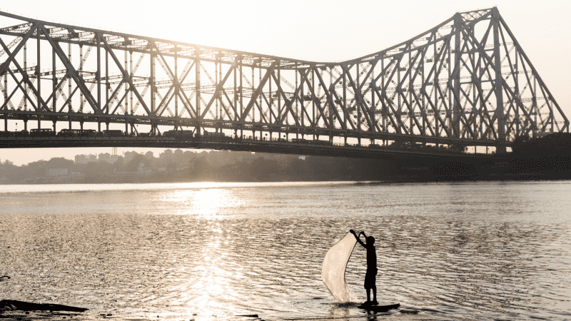 Sun rising over the Howrah Bridge in Kolkata, India