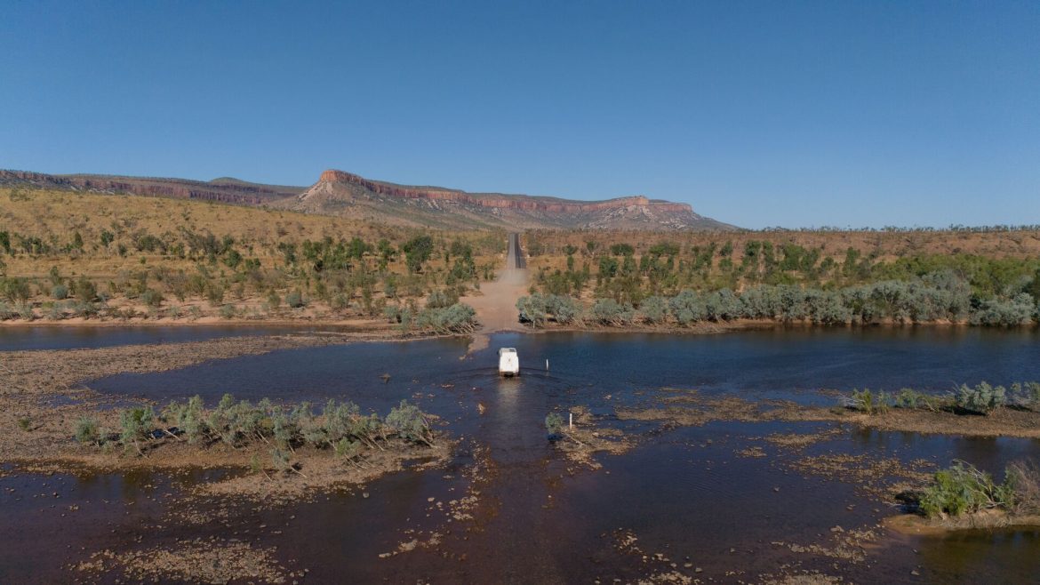 An Intrepid Overland truck drives across Pentecost River.
