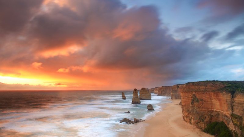 The striking figures of the Twelve Apostles as they rise out of the ocean beneath a multicoloured sunset