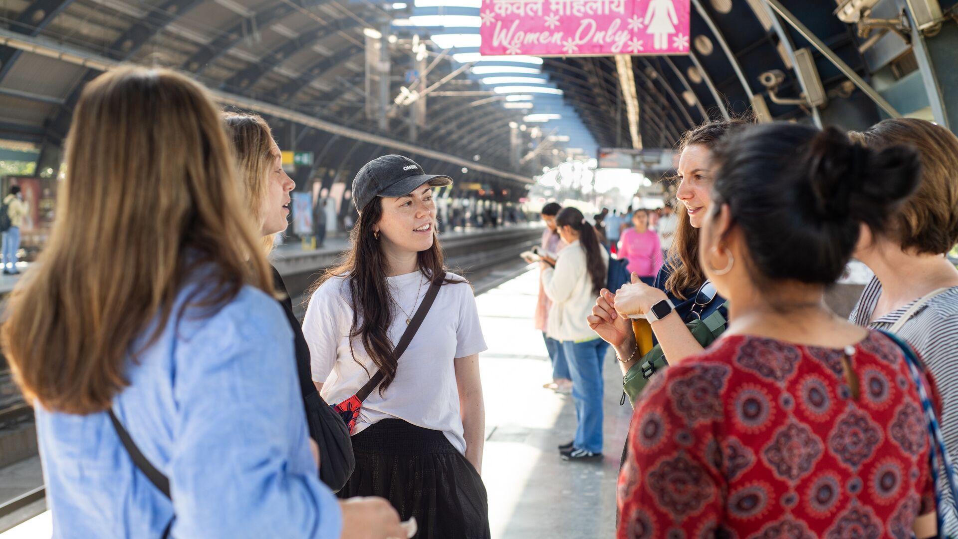 A group of women waiting for the train in India under the 'women only' sign.