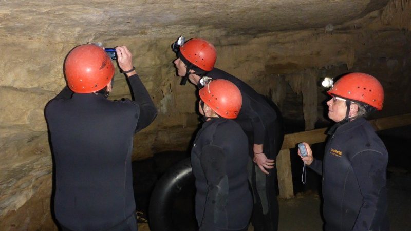 Travellers studying glow worms in cave