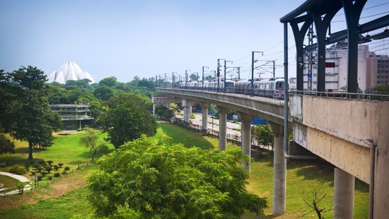 Train travels towards the Lotus Temple in Delhi