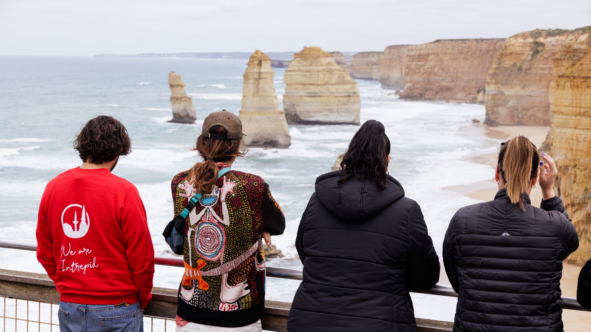 Four people look out over the Twelve Apostles site.