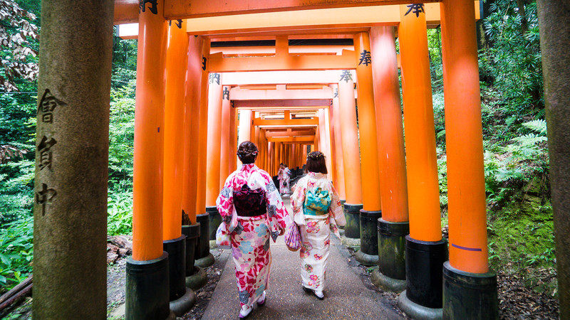 Two geishas walk through the Fushimi Shrine