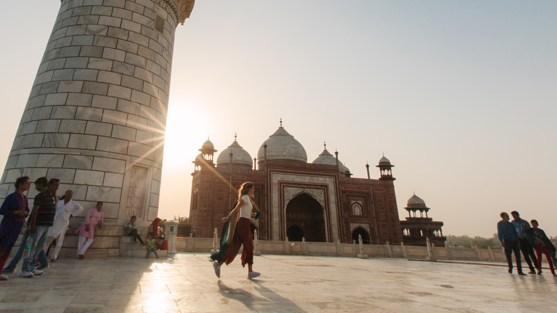 A woman walks around the Taj Mahal