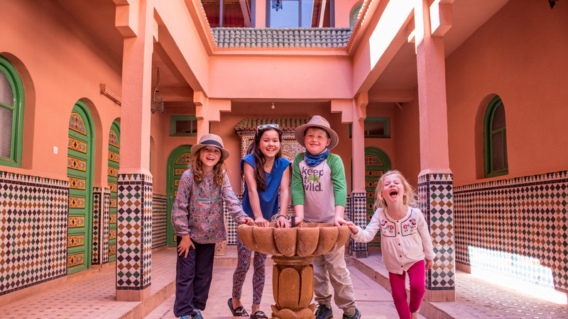 Kids stand around a fountain in a riad