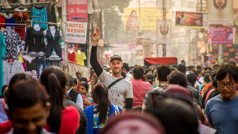 A traveller stands in a crowd of people in India