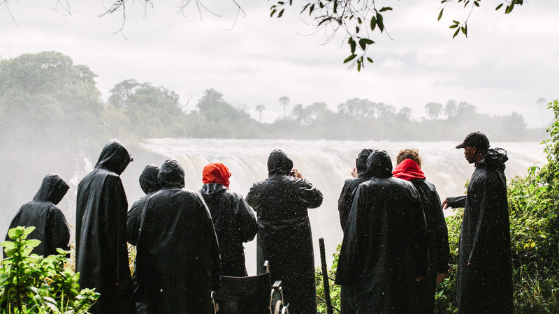 A group of travellers look at Victoria Falls