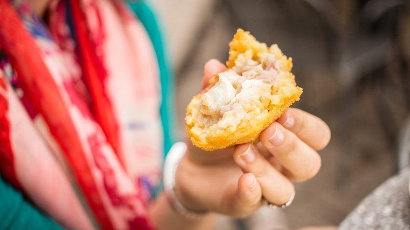 A woman eating arancino in Italy