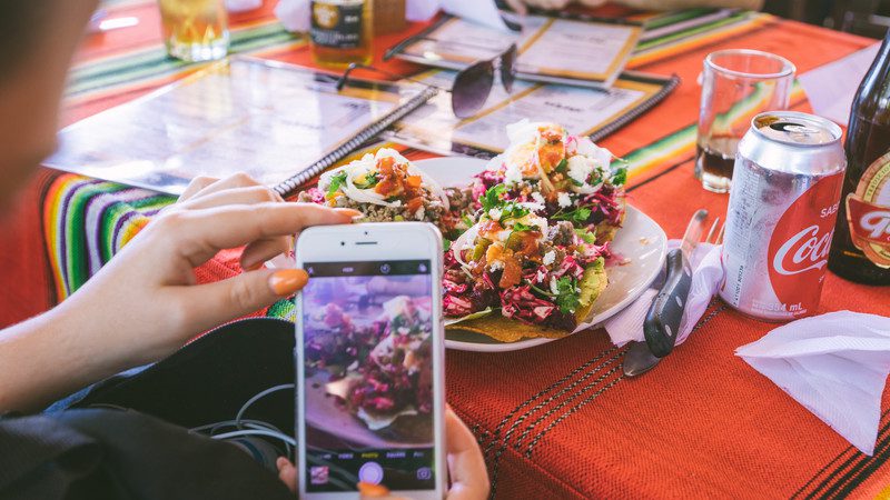 A traveller takes a photo of her food in Belize