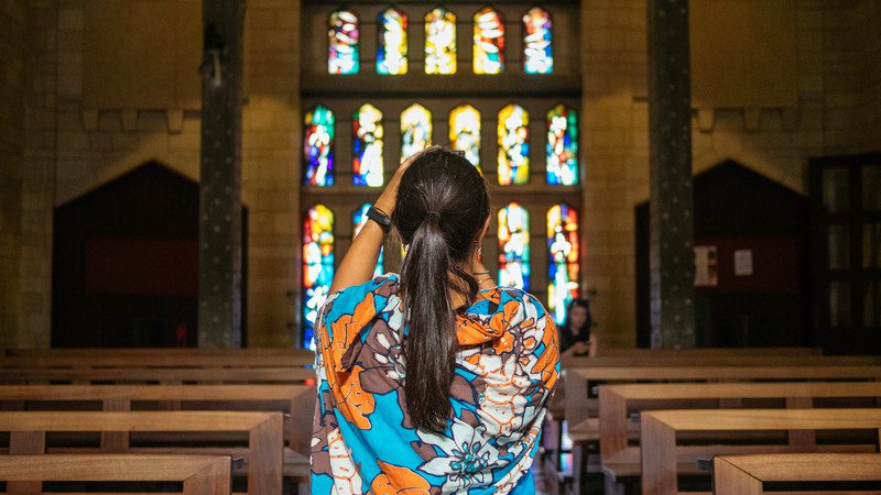 A female traveller photographing a stained-glass window