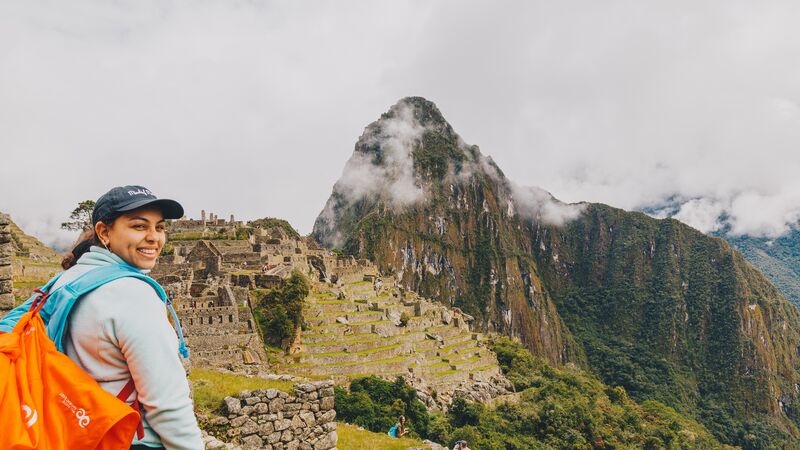 A young woman smiles at the camera at Machu Picchu