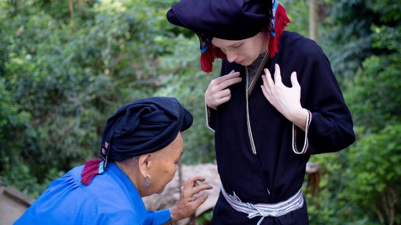 A woman is fitted in a traditional costume in Sung Village