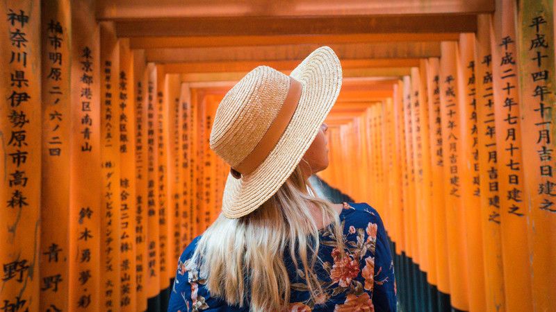 Girl walks through shrine in Japan.