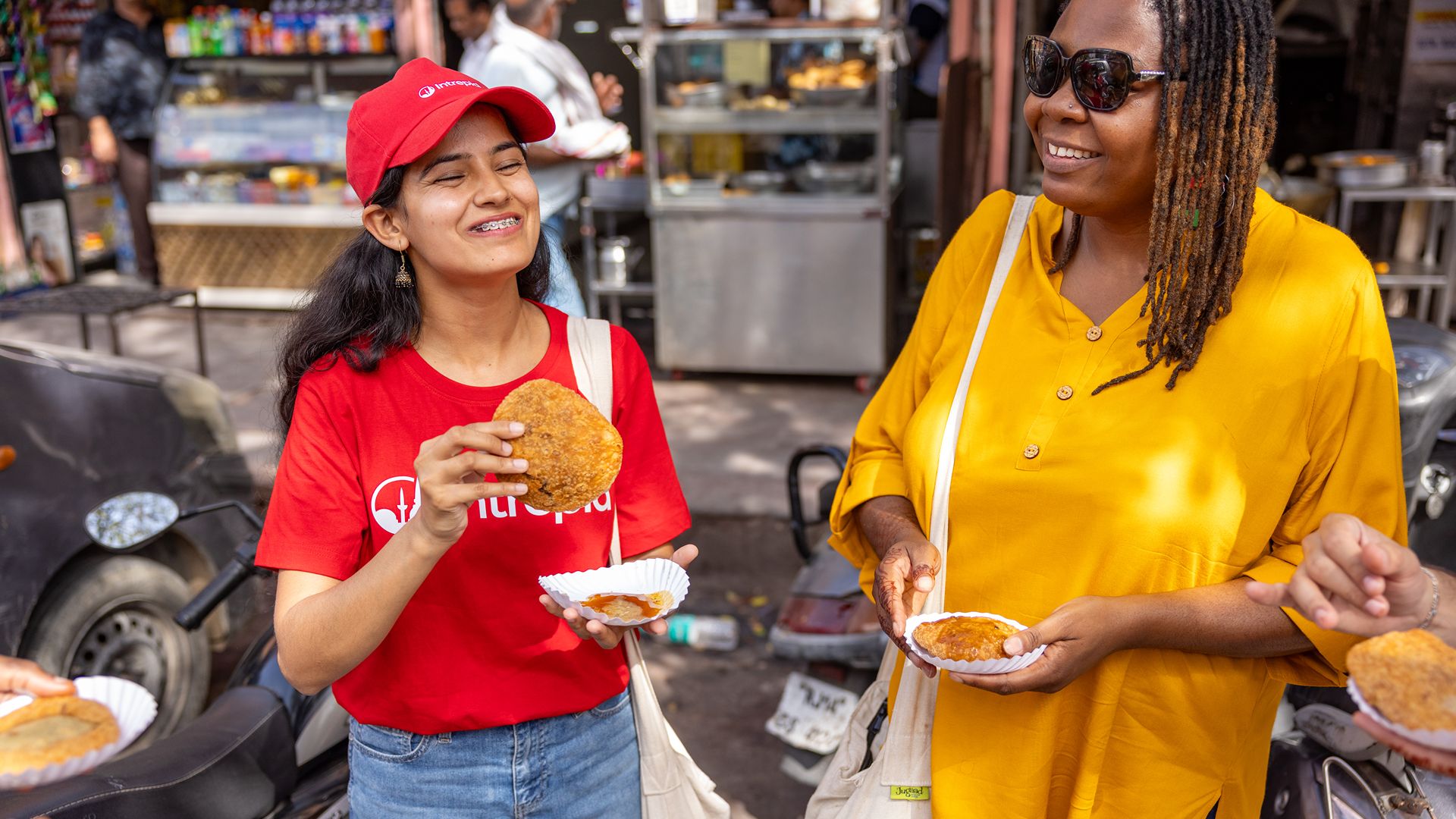 A traveller trying street food in India with Intrepid's local leader.